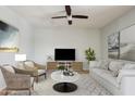 Cozy living room with neutral tones, a ceiling fan, and ample natural light at 18061 W Post Dr, Surprise, AZ 85388