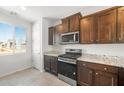 Stylish kitchen showcasing stainless steel appliances, granite countertops, dark wood cabinetry, and a bright window at 21292 N 270Th Dr, Buckeye, AZ 85396