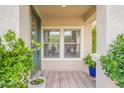 Cozy covered front porch with neutral-striped welcome mat and vibrant potted plants at 2469 S Sailors Ct, Gilbert, AZ 85295