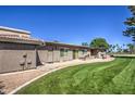 Spacious backyard featuring well-maintained grass, gravel landscaping, and a covered patio area at 25273 S Berry Brook Dr, Sun Lakes, AZ 85248
