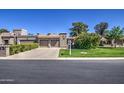 Attractive single-story home featuring a manicured lawn, mature shrubs, and a convenient two-car garage at 25273 S Berry Brook Dr, Sun Lakes, AZ 85248