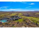 Breathtaking aerial view of a golf course and community surrounded by desert landscape and blue skies at 2550 W Pumpkin Ridge Dr, Anthem, AZ 85086