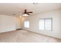 Bright living room with neutral carpet, ceiling fan, and large windows with blinds at 2624 E La Costa Dr, Chandler, AZ 85249