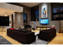 A spacious living room featuring a fireplace, piano, modern decor, and large windows offering picturesque outdoor views at 29218 N 107Th Way, Scottsdale, AZ 85262