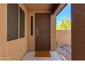 A protected entrance featuring a secure decorative metal door, welcome mat, and adjacent rock garden at 29374 N 68Th Ln, Peoria, AZ 85383