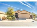 Charming single-Gathering home featuring desert landscaping, a beige stucco exterior, and a two-car garage at 31013 N Claridge Cir, San Tan Valley, AZ 85143