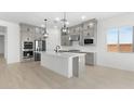 Bright kitchen with gray cabinetry, white counters, and modern stainless steel appliances at 37650 W Nina St, Maricopa, AZ 85138