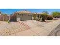 Charming single-story home with a beige exterior, tile roof, and well-maintained landscaping at 3805 S 73Rd Dr, Phoenix, AZ 85043