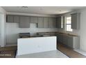 A kitchen with ample cabinet space and an island, providing a functional and stylish cooking environment at 43372 N Wollemi St, Queen Creek, AZ 85140