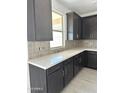 A modern kitchen counter with dark wood cabinets and white countertops and tile backsplash at 43373 N Wollemi St, Queen Creek, AZ 85140