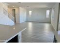 An open-concept living room with modern finishes, light wood-look floors, and bright natural light at 43373 N Wollemi St, Queen Creek, AZ 85140