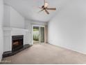 Bright living room with a fireplace, ceiling fan, and sliding glass doors at 4757 W Caron St, Glendale, AZ 85302