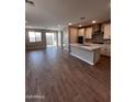 Bright, open kitchen with an island, stainless appliances, and a sliding glass door at 5633 N 205Th Ln, Buckeye, AZ 85396