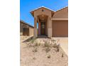Home entrance featuring an arched entryway with ample lighting and desert landscaping at 5641 N 205Th Ln, Buckeye, AZ 85396