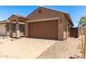 Home featuring an attached two-car garage with a tiled driveway and desert landscaping at 5641 N 205Th Ln, Buckeye, AZ 85396