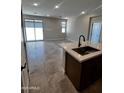Open floor plan with a kitchen island that features a stainless sink at 5641 N 205Th Ln, Buckeye, AZ 85396