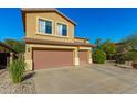 View of the exterior featuring the two-car garage, spacious driveway, and low maintenance desert landscaping at 6506 W Bent Tree Dr, Phoenix, AZ 85083