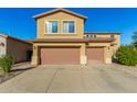 Exterior view of a two-story home with a spacious driveway and attached two-car garage with light brown garage doors at 6506 W Bent Tree Dr, Phoenix, AZ 85083