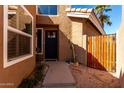 Inviting entryway with a dark front door, wood gate, desert landscaping, and a stylish exterior at 6520 E Sugarloaf St, Mesa, AZ 85215
