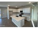 Spacious kitchen featuring white cabinets, modern appliances, a central island, and tile flooring at 7267 E Hackamore Ln, San Tan Valley, AZ 85143