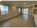A well-lit living room with multiple windows and sliding glass doors to the backyard at 7267 E Hackamore Ln, San Tan Valley, AZ 85143