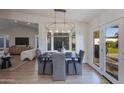 Dining area features a modern chandelier over a dark wood table and views to an outdoor space at 8031 E Redwing Rd, Scottsdale, AZ 85250