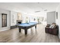 Bright, open living room featuring hardwood floors, a pool table, and a cozy seating area at 8201 E Piccadilly Rd, Scottsdale, AZ 85251