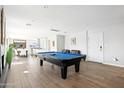 Spacious living room with hardwood floors, a pool table, and easy access to the kitchen at 8201 E Piccadilly Rd, Scottsdale, AZ 85251