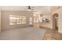 Bright living room with large windows, neutral paint, plush carpeting, and an open layout to the kitchen at 9715 E Osage Ave, Mesa, AZ 85212
