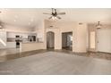 Open-concept living room featuring neutral tones, a ceiling fan, and seamless transition to the adjacent kitchen at 9715 E Osage Ave, Mesa, AZ 85212