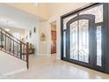 Grand foyer showcasing a decorative front door, soaring ceilings, and an elegant staircase at 10038 W Redbird Rd, Peoria, AZ 85383
