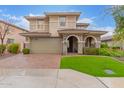 Two story home boasts manicured lawn, brick driveway and archway leading to the front door at 11544 W Ashby Dr, Peoria, AZ 85383