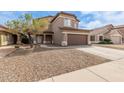 Two-story home with a brown garage door, neutral siding, and well-manicured landscaping at 13001 W Bloomfield Rd, El Mirage, AZ 85335