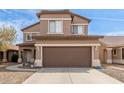 Two-story home with a brown garage door, neutral siding, and well-manicured landscaping at 13001 W Bloomfield Rd, El Mirage, AZ 85335