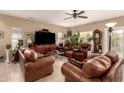 Spacious living room with leather furniture, ceiling fan, tile floors and lots of plants at 13001 W Bloomfield Rd, El Mirage, AZ 85335