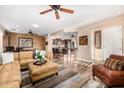 An open-concept living room features a leather sofa, wood floors, recessed lighting, and a ceiling fan at 13064 W Big Oak St, Peoria, AZ 85383