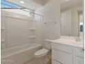 Clean bathroom featuring white fixtures, a shower-tub combo, and a large framed mirror at 21281 N 270Th Dr, Buckeye, AZ 85396