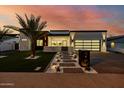 Modern home with drought-resistant landscaping, a sleek front entrance and a contemporary black framed garage at 2642 N Fiesta St, Scottsdale, AZ 85257