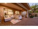 Relaxing covered patio featuring an oversized sofa, tile flooring, and decorative pillows at 32215 N 16Th Ave, Phoenix, AZ 85085
