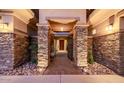 Inviting entrance with stone pillars, elegant lighting, and a decorative iron gate at 32215 N 16Th Ave, Phoenix, AZ 85085