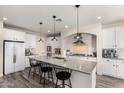 Bright kitchen featuring white cabinetry, granite countertops, pendant lighting, and stainless steel appliances at 4167 E Sierra Madre Ave, Gilbert, AZ 85296
