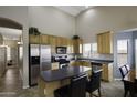 Spacious kitchen featuring stainless steel appliances, light wood cabinets, and a breakfast bar island at 43271 W Mcclelland Dr, Maricopa, AZ 85138
