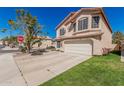 Charming two-story home with a tile roof, lush lawn, and an attached two-car garage at 439 N Cobblestone St, Gilbert, AZ 85234