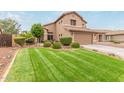 Beautiful front lawn, mature trees, and a two car garage enhance the curb appeal of this home at 6112 N Almanza Ln, Litchfield Park, AZ 85340