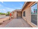 Home exterior featuring brickwork, patio, and desert landscaping at 6126 W Sweetwater Ave, Glendale, AZ 85304