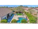 Aerial view of a backyard with a pool, outdoor kitchen, fireplace, mature trees, and lush landscaping at 722 W Claremont St, Phoenix, AZ 85013
