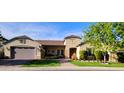 Charming single-story home featuring a manicured lawn, brick walkway, and an inviting facade with stone accents at 722 W Claremont St, Phoenix, AZ 85013