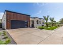 Contemporary home showcasing a spacious driveway and a striking wood-paneled garage, complemented by desert landscaping at 7325 E Virginia Ave, Scottsdale, AZ 85257