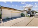 Elegant home showcasing a spacious driveway leading to a two-car garage and desert landscaping at 7705 E Doubletree Ranch Rd # 36, Scottsdale, AZ 85258
