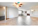 Spacious, light-filled open-concept living room features tile floors and a ceiling fan. View into kitchen with counter seating at 900 S 94Th St # 1204, Chandler, AZ 85224